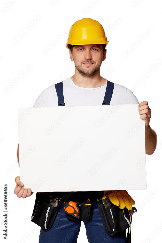 caucasian repairman worker in uniform and hard hat holding empty blank board. handyman wearing tool belt isolated on white studio background caucasian repairman worker in uniform and hard hat holding empty blank board. handyman wearing tool belt isolated on white studio background