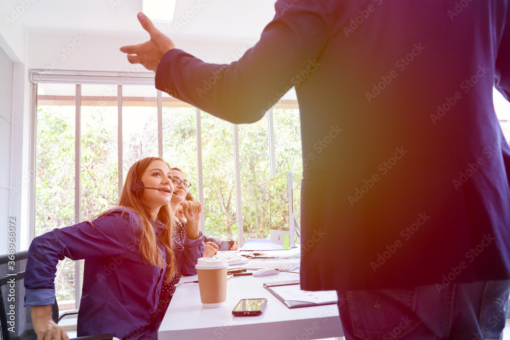 © torsakh - Business people or Manager talking with staff or colleagues and working by using headphone or headset in conference room or telecommunication meeting with customer, contact call centre office concept