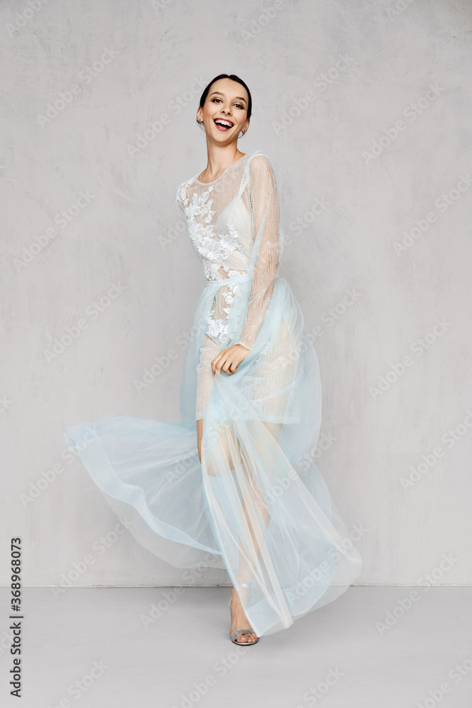 Beautiful young woman plays with hem of transparent tulle dresses with lace Beautiful young woman plays with hem of transparent tulle dresses with lace