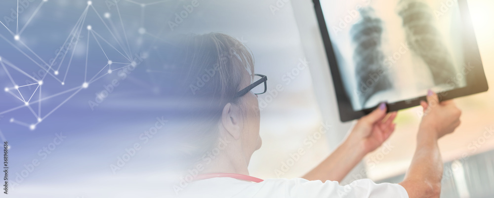 Female doctor looking at x-ray; panoramic banner