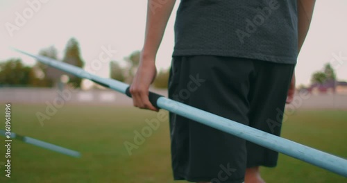 Close-up: Hand a Male athlete at the stadium takes a javelin for throwing and prepares to make a throw. Goes takes the spear. Training of a javelin thrower photo