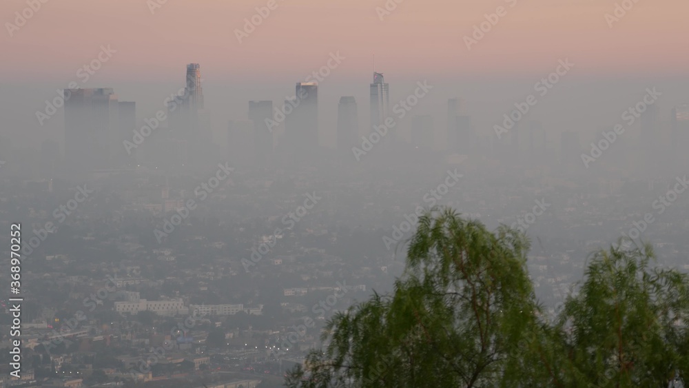 Highrise skyscrapers of metropolis in smog, Los Angeles, California USA. Air toxic pollution and misty urban downtown skyline. Cityscape in dirty fog. Low visibility in city with ecology problems