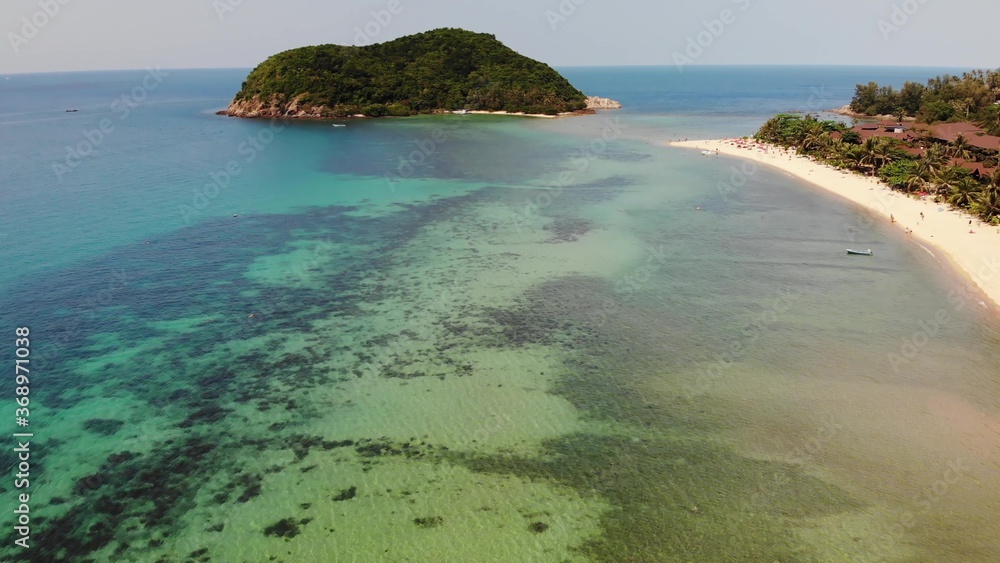 Aerial drone view small Koh Ma island, Ko Phangan Thailand. Exotic coast panoramic landscape, Mae Haad beach, summer day. Sandy path between corals. Vivid seascape, mountain coconut palms from above. Aerial drone view small Koh Ma island, Ko Phangan Thailand. Exotic coast panoramic landscape, Mae Haad beach, summer day. Sandy path between corals. Vivid seascape, mountain coconut palms from above.