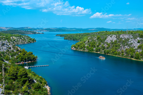 View from the Sibenik Bridge to the canyon Krka River towards Adriatic Sea . Bird view, sky with clouds.