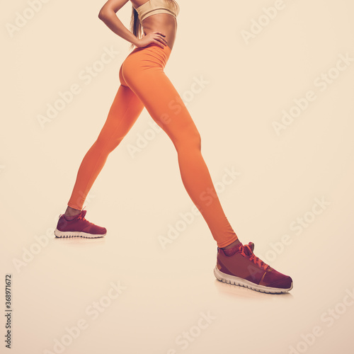 Sporty woman with fit muscular legs stretching, closeup photo