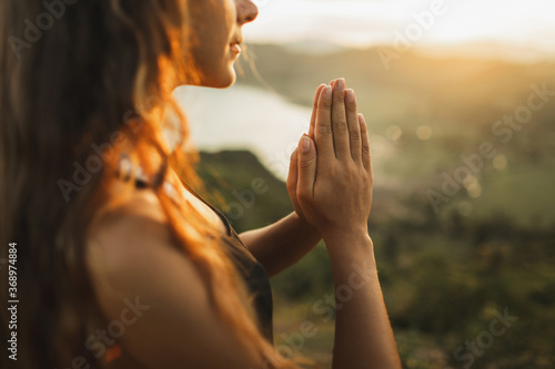 Woman praying alone at sunrise. Nature background. Spiritual and emotional concept. Sensitivity to nature photo