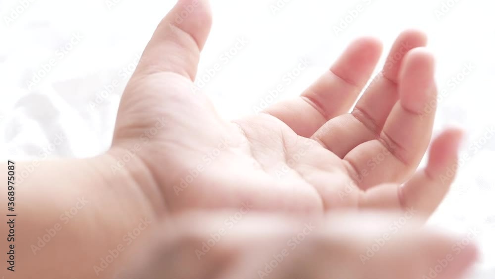 Close up motion of child hand on white fabric background. Close up motion of child hand on white fabric background.