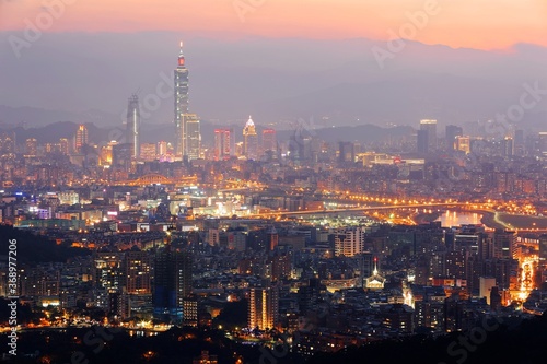Panoramic aerial view of crowded Taipei City, Taipei landmark, XinYi Commercial District, Keelung River and downtown area at moody dusk ~ Taipei City skyline in evening twilight