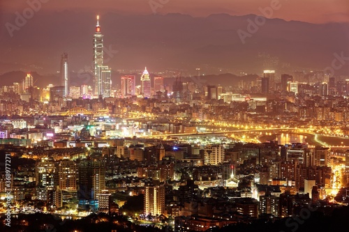 Panoramic aerial view of crowded Taipei City, Taipei landmark, XinYi Commercial District, Keelung River and downtown area at moody dusk ~ Taipei City skyline in evening twilight