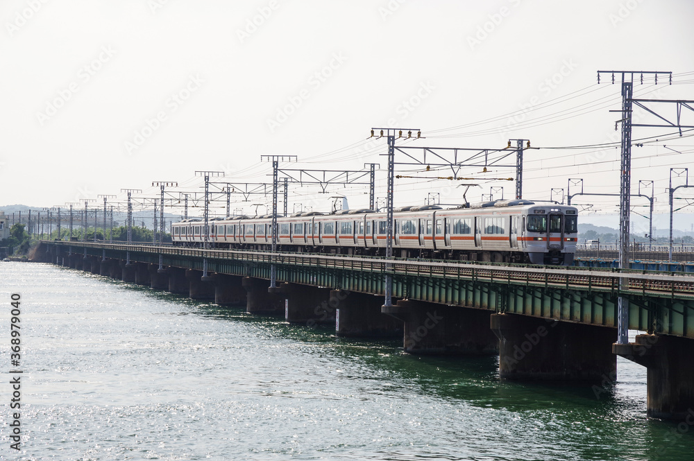浜名湖を跨ぐ鉄橋を走る電車