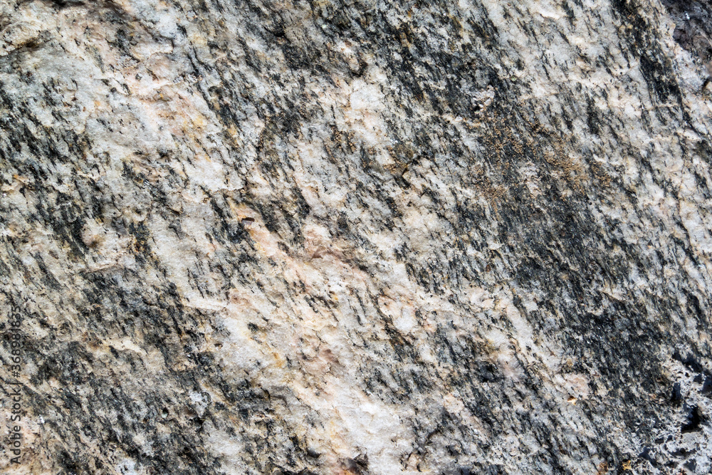 Close up view onto rough surface of split granite stone with its granular and phaneritic in texture