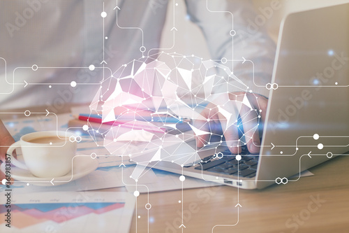 Businessman with computer background with brain theme hologram. Concept of brainstorm. Multi exposure.