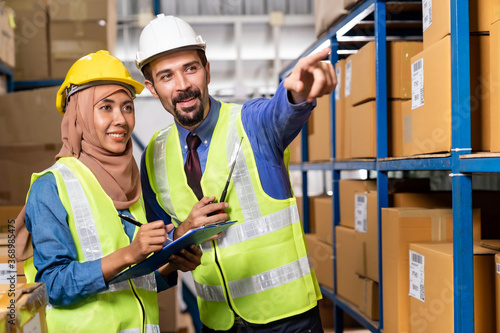 Warehouse manager and muslim worker working inventory photo