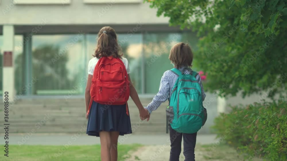 Children go back to school. Cute pupils with backpacks. Boy and girl in safety masks. Children go back to school. Cute pupils with backpacks. Boy and girl in safety masks.