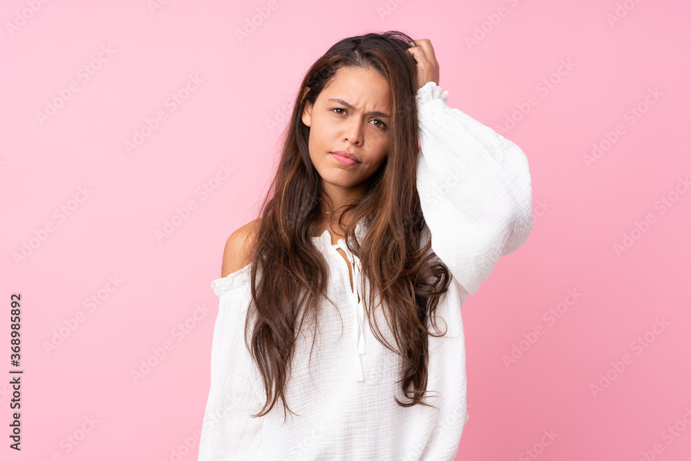 Young Brazilian girl over isolated pink background with an expression of frustration and not understanding