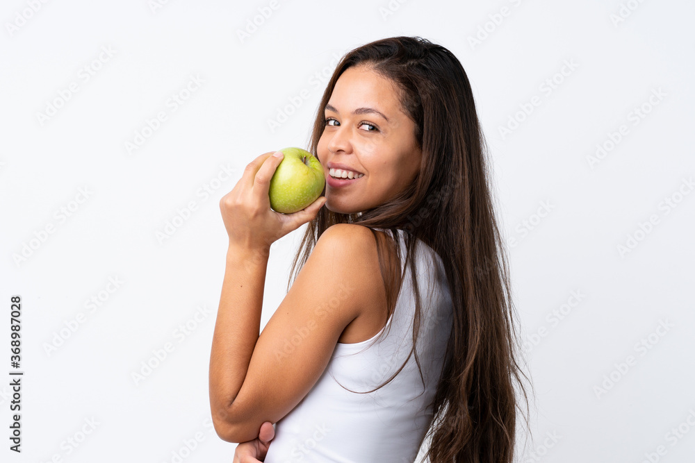 Young Brazilian girl with an apple over isolated background Young Brazilian girl with an apple over isolated background