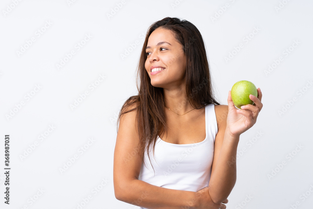 Young Brazilian girl with an apple over isolated background Young Brazilian girl with an apple over isolated background