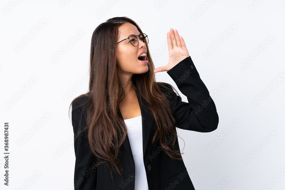 Young Brazilian girl with blazer over isolated white background shouting with mouth wide open Young Brazilian girl with blazer over isolated white background shouting with mouth wide open