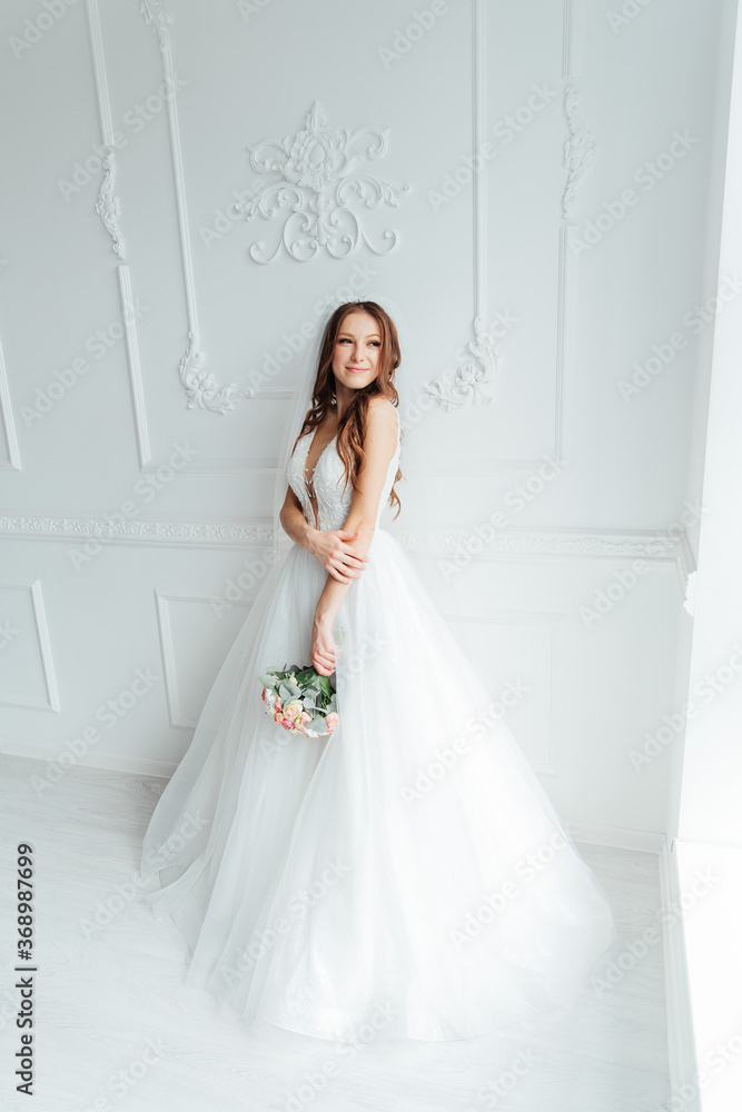 The first meeting of the groom in a black suit and the bride in a white wedding dress with a bouquet in the interior of a photo studio on a white and black background The first meeting of the groom in a black suit and the bride in a white wedding dress with a bouquet in the interior of a photo studio on a white and black background