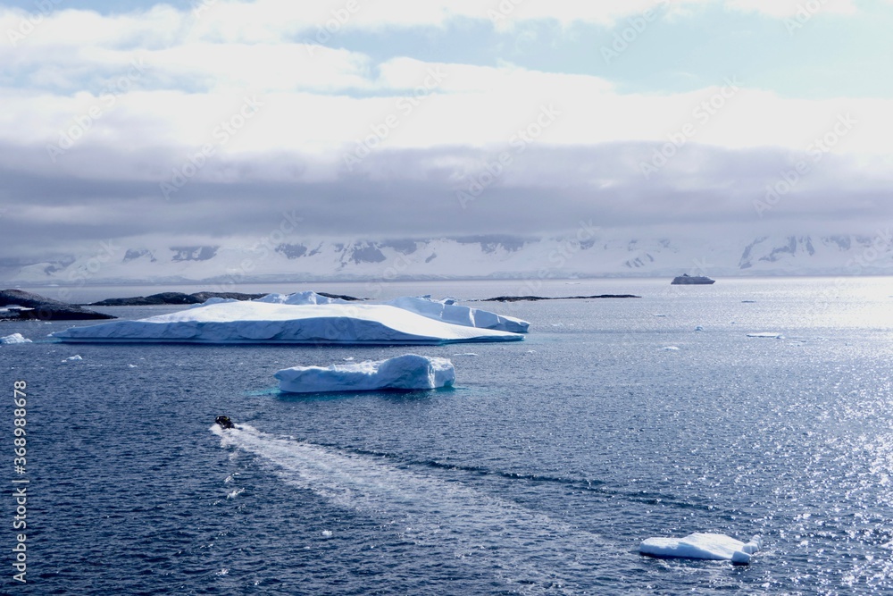 Fototapeta premium Rubber boat in antarctic landscape with blue water, iceberg, glacier, Antarctica
