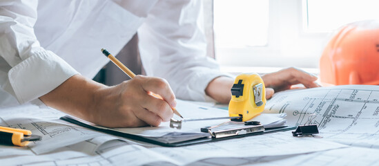 architect design working drawing sketch plans blueprints and making architectural construction model in home.