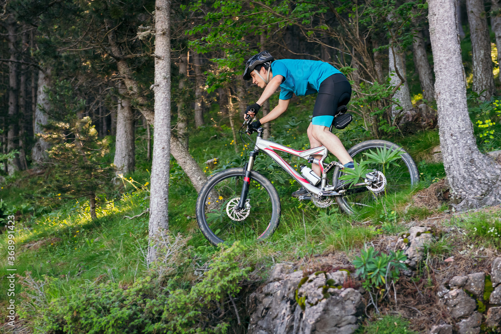 boy riding fast a mountain bike through a forest boy riding fast a mountain bike through a forest