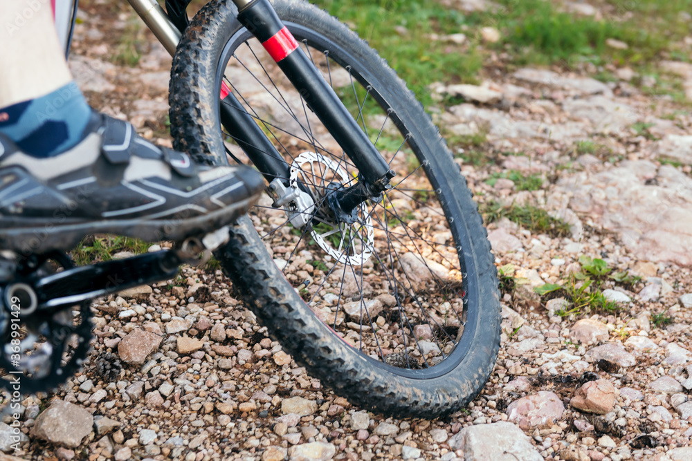 detail of a mountain bike wheel on a rocky terrain
