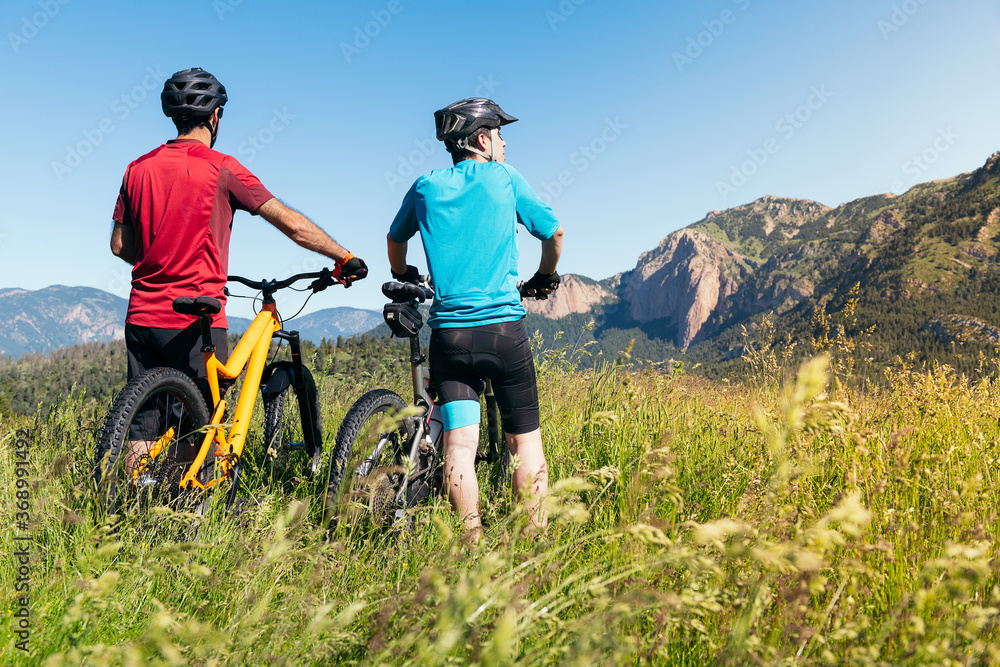 two men with their bikes looking the mountains