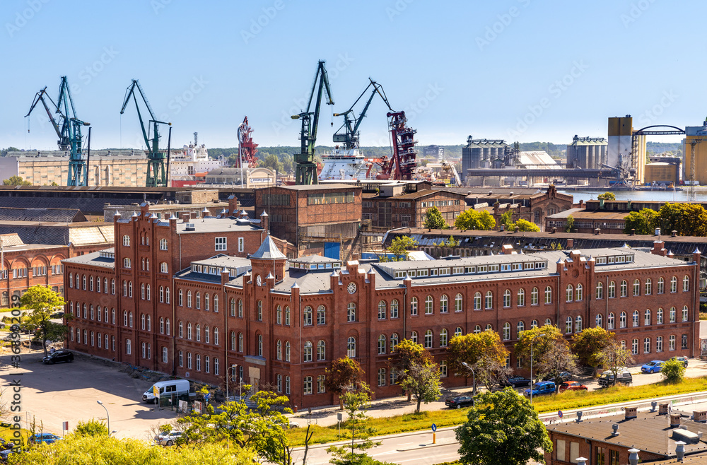 Panoramic view of Gdansk Shipyard industrial infrastructure with shipyard directorate main historic building in Gdansk, Poland - obrazy, fototapety, plakaty 
