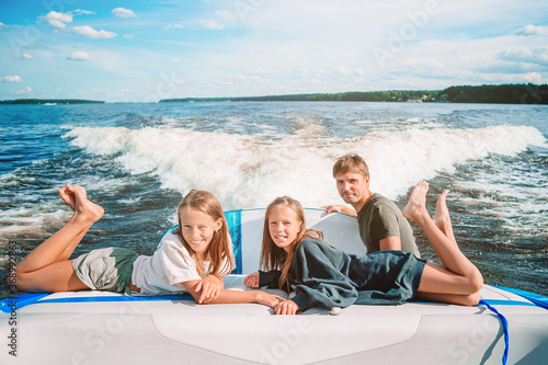 Family sailing on boat in clear open sea photo