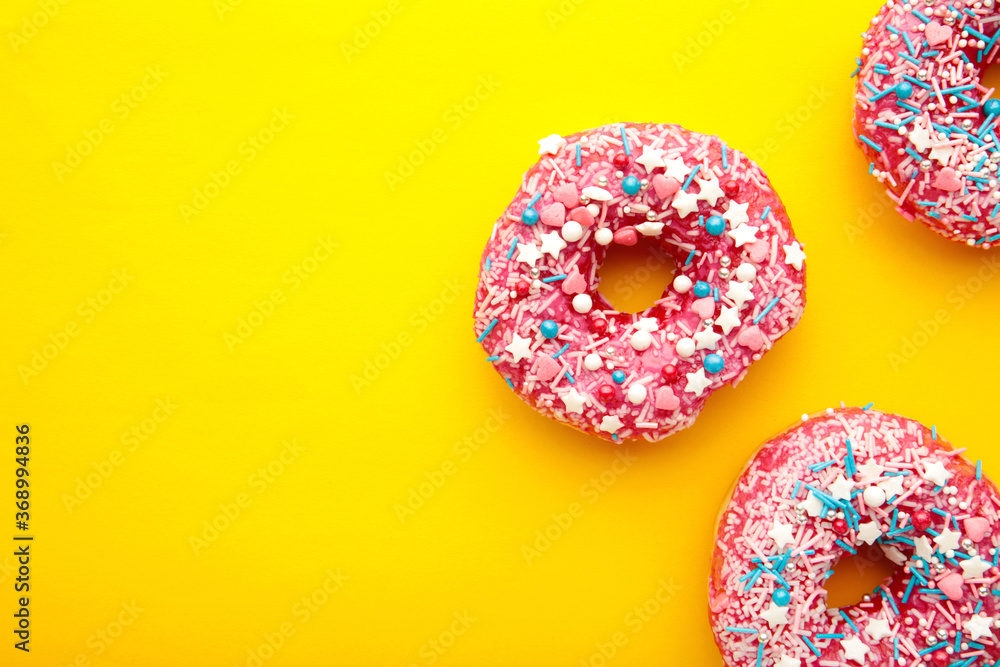 Raspberry donut with icing on a yellow background. Top view. Minimal concept. Raspberry donut with icing on a yellow background. Top view. Minimal concept.