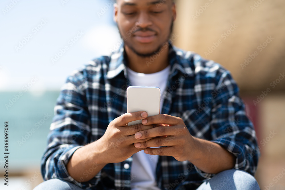 Portrait of black person texting sms on smart phone Portrait of black person texting sms on smart phone