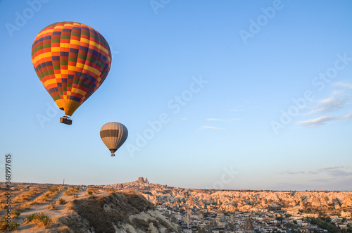 Hot air balloon flying with Uchisar castle on background. Cappadocia, Turkey