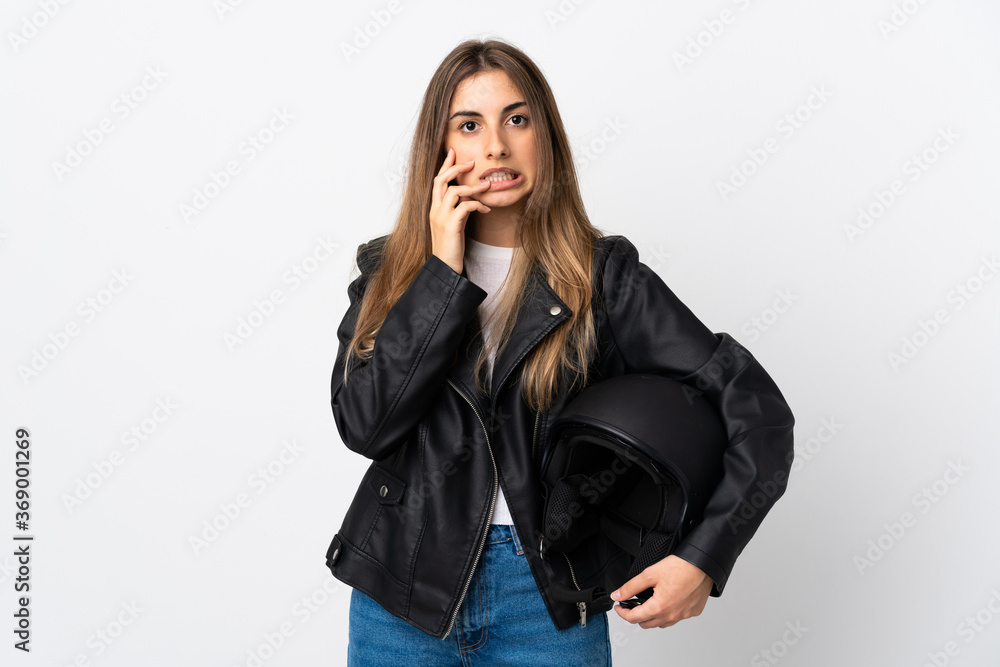 Young Woman holding a motorcycle helmet over isolated white background nervous and scared - obrazy, fototapety, plakaty 