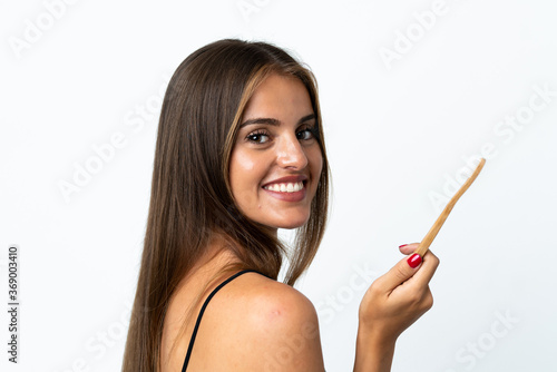 Young Uruguayan woman isolated on white background with a toothbrush and happy expression