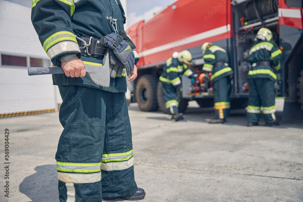 Portrait of strong male wearing green work uniform with gloves on the belt Portrait of strong male wearing green work uniform with gloves on the belt