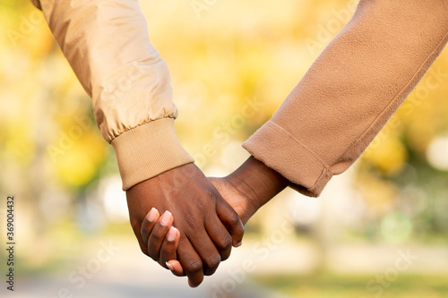 Romantic african american couple holding hands outdoors, closeup © Prostock-studio
