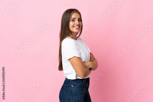 Young Uruguayan woman isolated on pink background with arms crossed and happy