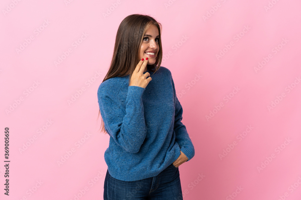 Young Uruguayan woman isolated on pink background looking up while smiling Young Uruguayan woman isolated on pink background looking up while smiling