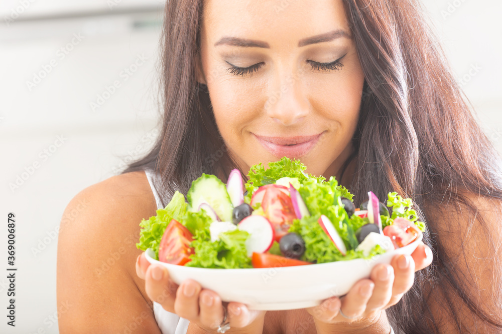 Attractive young and happy woman eating vegetable salad Attractive young and happy woman eating vegetable salad