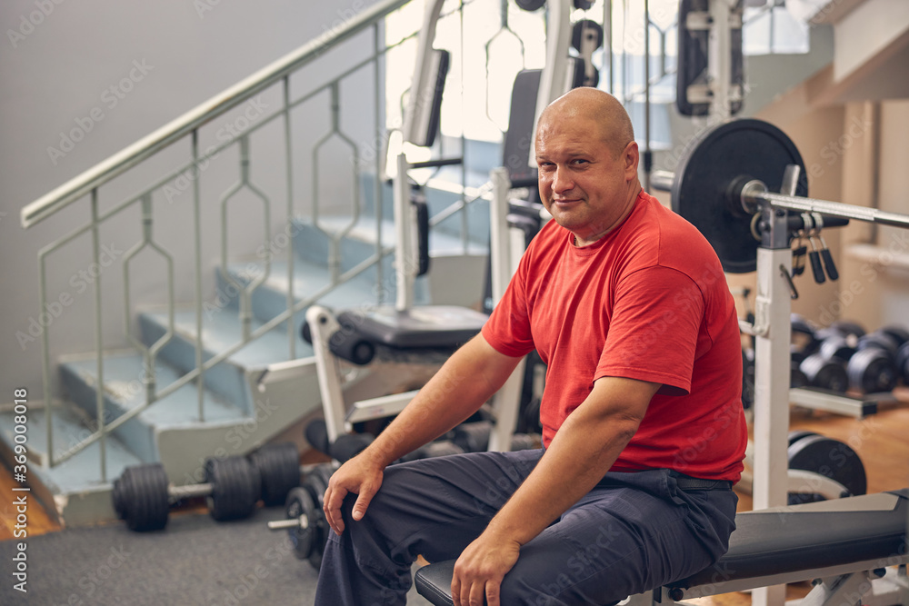 Handsome smiling man sitting on the coach in sport center Handsome smiling man sitting on the coach in sport center