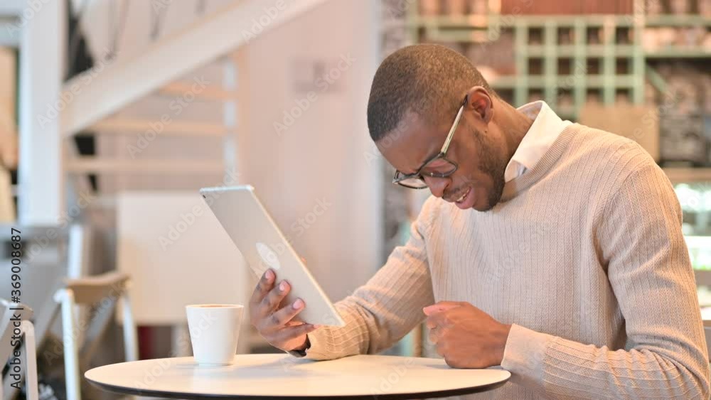 Disappointed African Man reacting to Loss on Tablet in Cafe Disappointed African Man reacting to Loss on Tablet in Cafe