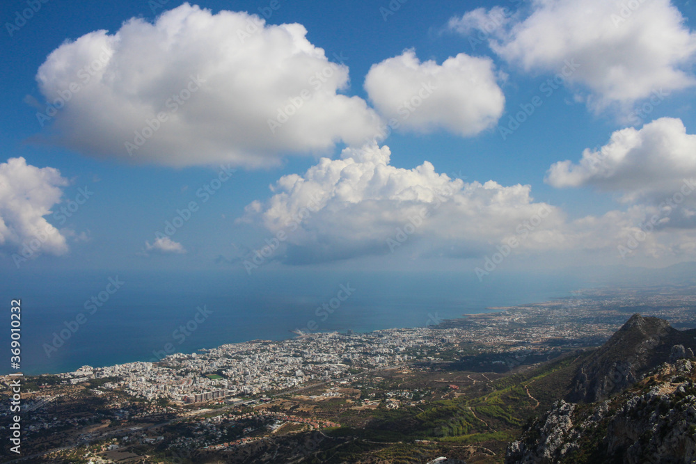 View from the castle of Saint Hilarion on the city of Kyrenia, mountains, fluffy clouds and the Mediterranean sea. Cyprus.