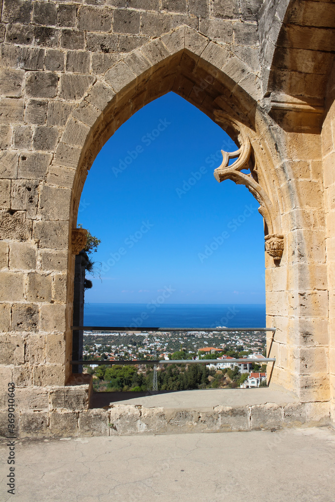 Bellapais Abbey arch with views of Kyrenia, the sea and the bright blue sky. White Abbey, the Abbey of the Beautiful world...