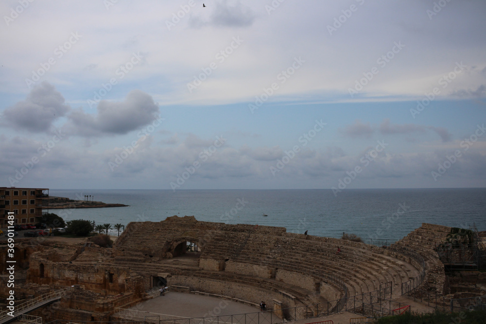 Obraz premium Roman amphitheater of Tarraco in Tarragona on the background of sea and sky, Costa Blanca, Spain.
