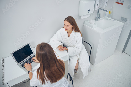Woman discussing something with cosmetologist before treatments procedure