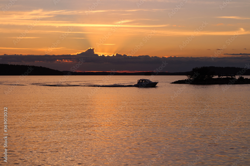 The boat returns to the pier at sunset, which sets in clouds. Lake Vesijärvi. Lahti. Finland. The boat returns to the pier at sunset, which sets in clouds. Lake Vesijärvi. Lahti. Finland.