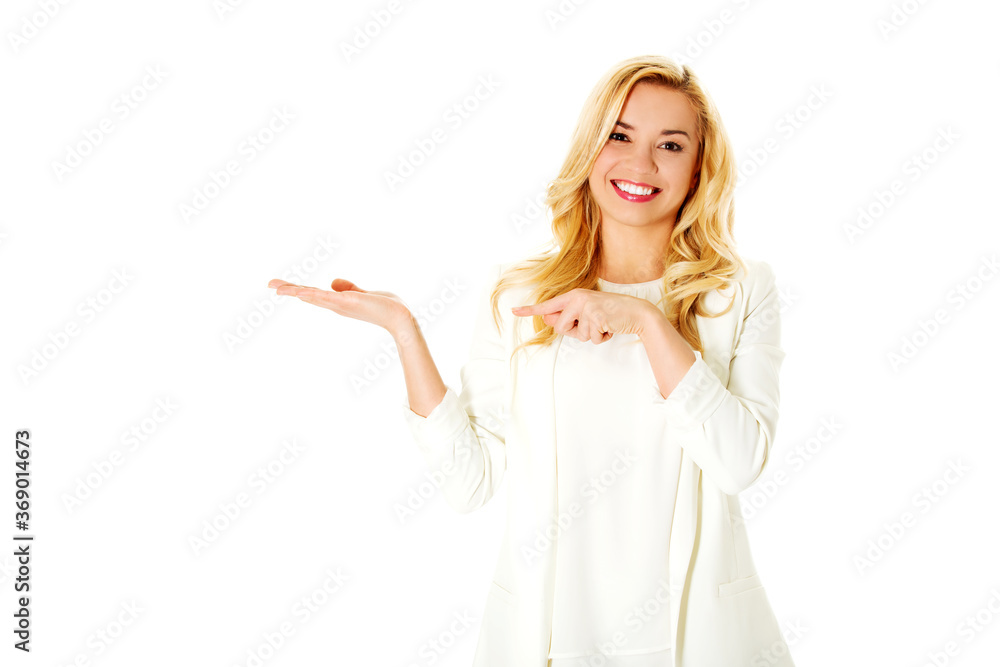 Suprised woman showing something, for exaple product with her finger. Suprised woman showing something, for exaple product with her finger.