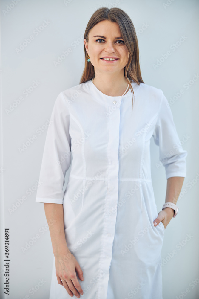Professional beauty specialist holding hand on the pocket of white coat Professional beauty specialist holding hand on the pocket of white coat