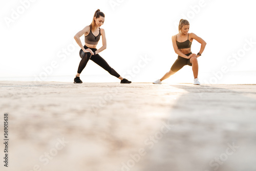 Women friends outdoors making stretching exercises